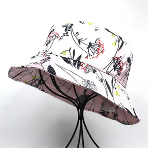 Close-up of pink silk-like bucket hat with floral print on black metal display stand