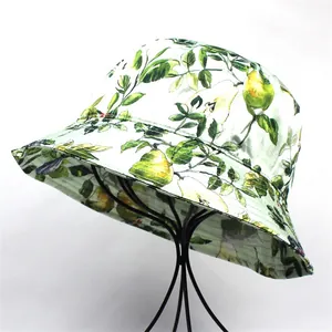 Detail of printed bucket hat with green leaves and yellow pear patterns on white fabric