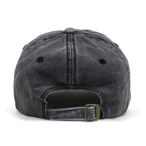 Detail of the washed cotton baseball cap featuring a brass buckle and stitching