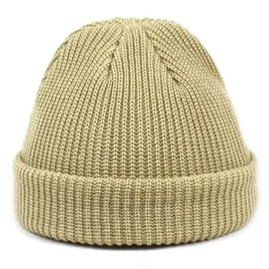 Detailed view of the khaki ribbed knit texture and folded cuff of the acrylic beanie