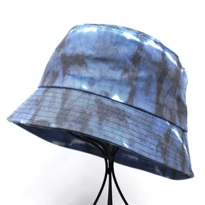 Detail of blue tie-dye bucket hat fabric texture on a minimalist wire stand