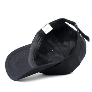 Internal structure of black cotton baseball cap showing sweatband and adjustable buckle