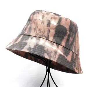 Close-up of a tie-dye bucket hat in brown and black on a black wire display stand