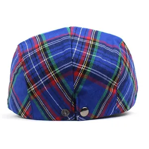 Detail view of the metal adjustment buckle and blue plaid pattern on the newsboy cap