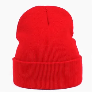 Close-up of vibrant red acrylic knit beanie with ribbed texture and wide cuffed brim