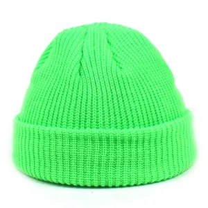 Detail of the chunky knit texture and folded cuff on a neon green docker hat