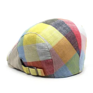 Detail of colorful patchwork plaid beret showing metal buckle and woven texture