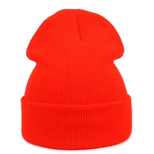 Close-up of bright orange ribbed knit beanie showing thick acrylic texture and wide fold