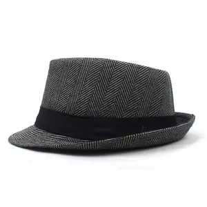 Macro view of menswear jazz hat showing refined black grey herringbone wool texture