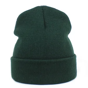 Macro detail of dark green knit beanie featuring a vertical ribbed pattern and wide cuff