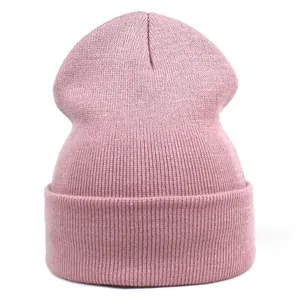 Close-up of soft pink knitted beanie with vertical ribbed texture and wide folded cuff