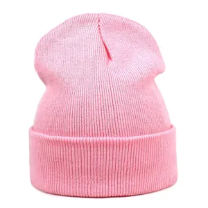 Close-up of pink knitted beanie showing vertical rib knit pattern and soft acrylic texture