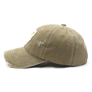 Detailed side view of khaki washed cotton baseball cap with distressed brim and patch