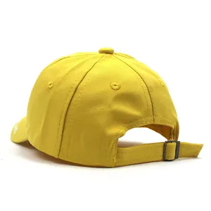 Detail view of the yellow cotton baby cap featuring the metal buckle and stitching