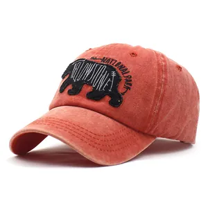 Washed red cotton baseball cap with embroidered brown bear and Yellowstone National Park logo