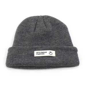 Dunkelgraue Strickmütze mit weißem Etikett für Damen und Herren im Winter