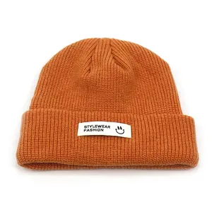 Nahaufnahme der orangen Strickmütze mit weißem 'STYLEWEAR' Smiley-Logo-Aufnäher