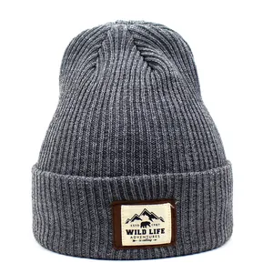 Detailed view of dark grey ribbed knit beanie with mountain wildlife woven patch