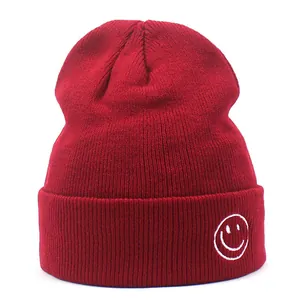 Berretto invernale in maglia bordeaux con risvolto ampio e faccina sorridente ricamata bianca