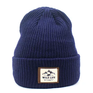 Detailed close-up of dark blue ribbed beanie featuring an outdoor wildlife adventure patch