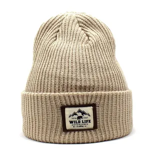 Close-up of khaki ribbed knit beanie featuring a Wild Life Adventures patch with bear graphic