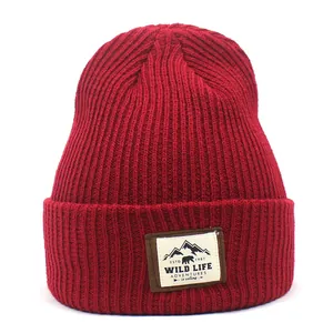 Close-up of deep red ribbed beanie showing the Wild Life mountain patch detail