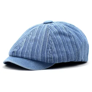 Detailed view of light blue denim newsboy cap with vertical stripe texture and top button