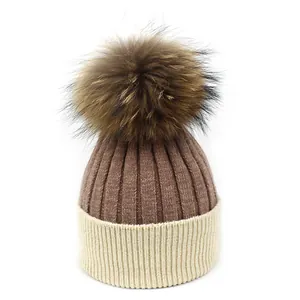Détail de la maille et pompon en fourrure sur bonnet d'hiver en laine bicolore