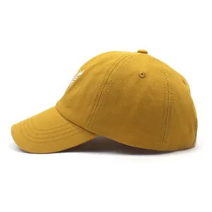 Detalle de gorra de béisbol amarillo mostaza con bordado de plumas y costuras