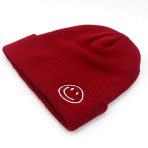 Berretto invernale unisex in maglia bordeaux con ricamo bianco a forma di faccina