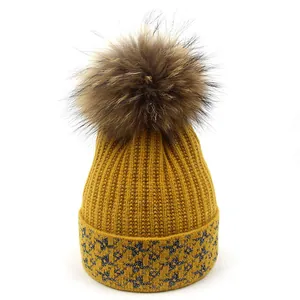 Winter beanie with raccoon fur pompom and silver metallic thread in yellow knit