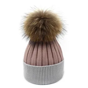 Détail de la maille côtelée sur un bonnet d'hiver bicolore avec un pompon en fourrure