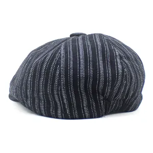 Detail of vintage navy blue pinstripe newsboy cap with top button and twill texture