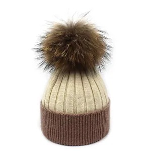 Détail du bonnet en laine avec bord côtelé marron et pompon en fourrure duveteuse