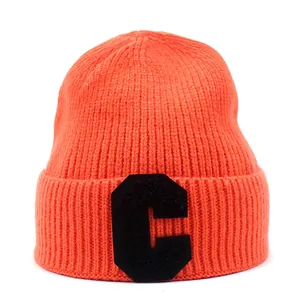 Detail view of ribbed knit orange beanie with black letter C patch embroidery