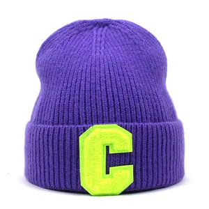 Purple ribbed knit beanie with neon yellow C letter patch on white background