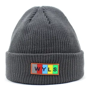 Close-up of dark grey knit beanie with colorful WYLS letter patch and fine texture