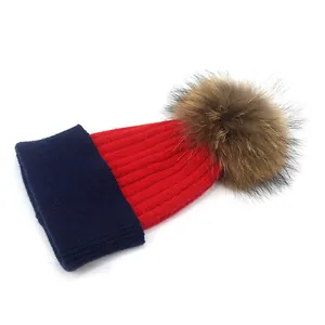 Bonnet en tricot bicolore rouge et bleu marine avec pompon en fausse fourrure