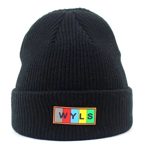 Detail of the black ribbed knit beanie with colorful WYLS rectangle logo label