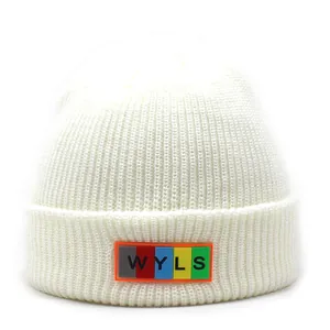 Detailed view of white ribbed knit beanie featuring a colorful WYLS letter rubber patch