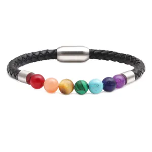 Dettaglio di perle in pietra colorata e cinturino in pelle intrecciata con chiusura magnetica