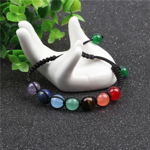 Handmade yoga chakra bracelet with 7 healing stones on a ceramic hand display stand