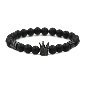 Makroaufnahme von matten schwarzen Onyxperlen mit mikrogepflastertem Kronenanhänger auf Armband