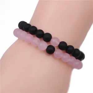 Detail of matte black and pink 8mm beaded bracelets worn on wrist for couples