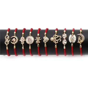 Set of ten gold red string bracelets with cubic zirconia charms in butterfly and heart designs