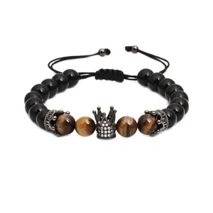 Detail of adjustable beaded bracelet featuring tiger eye stones and a black crown charm