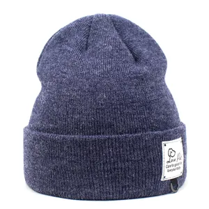Detail van donkerblauwe gebreide muts met Love Pet logo patch en decoratieve D-ring