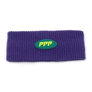 Detailed view of purple ribbed knit headband with a green logo patch for outdoor warmth