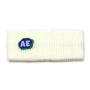 Detail of cream ribbed knit headband featuring a blue and green AE rubber logo patch