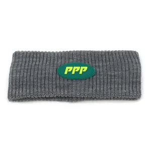 Detail of grey knitted winter headband featuring a green patch with yellow PPP lettering